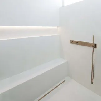 Tuš z mikrocementom in kanaleto Carrodrain Liquid — ob klopci je vidna le ozka reža