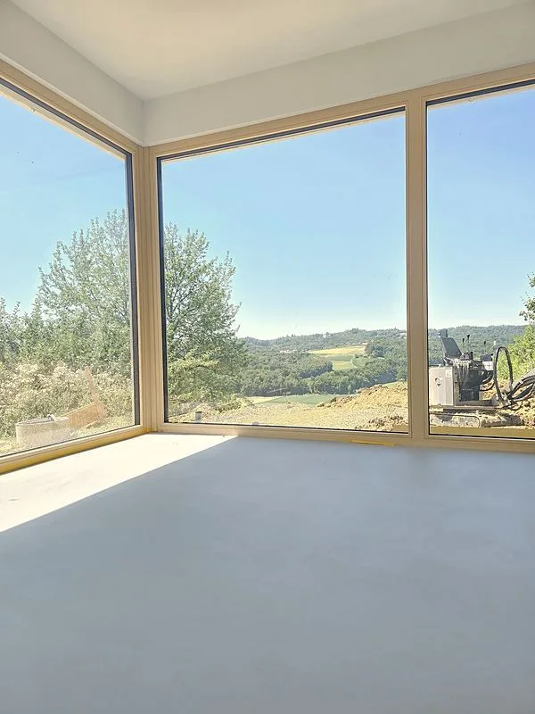 Montažna hiša Lumar — notranji tlak iz mikrocementa Microne ob panoramskih oknih